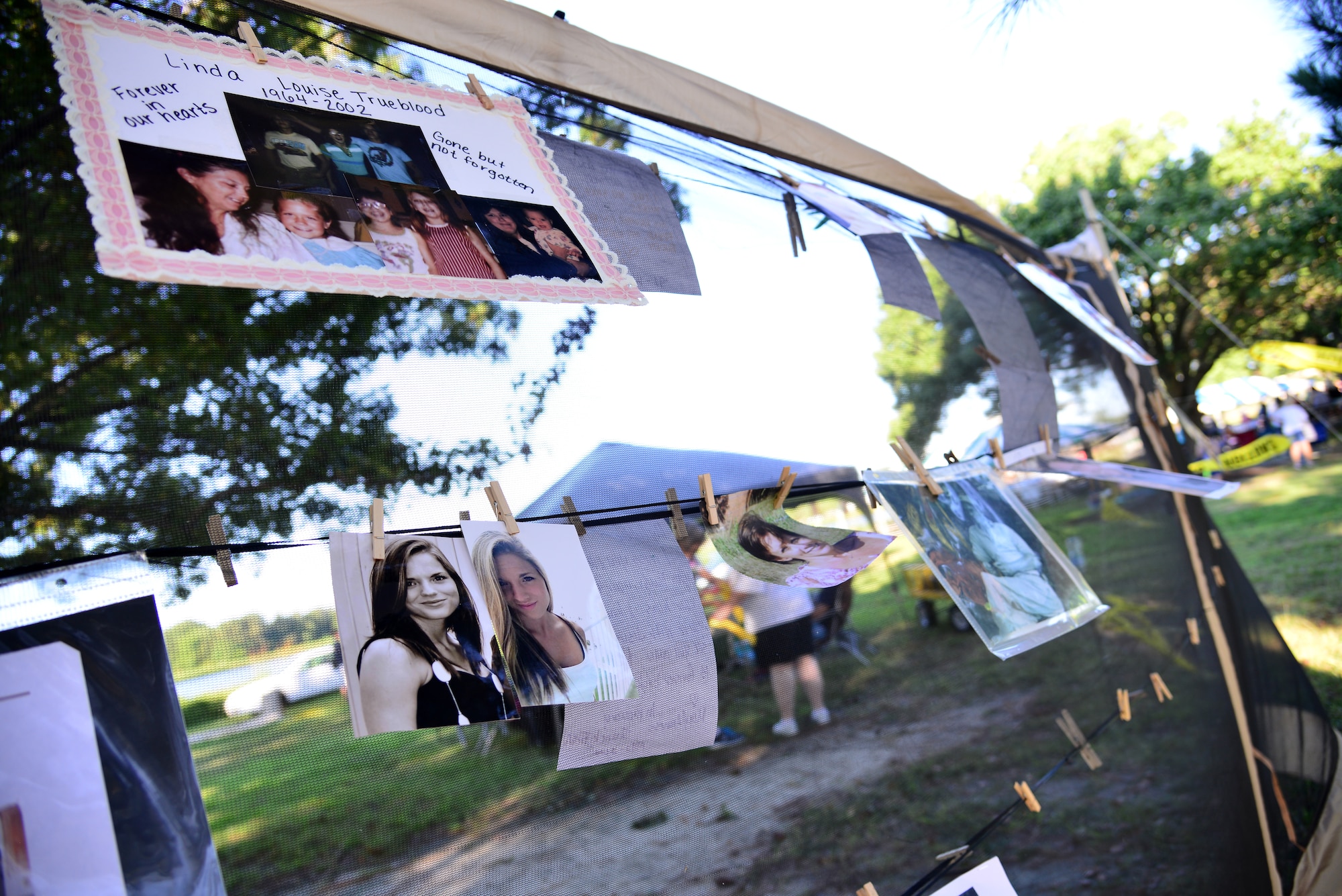 Pictures hang from a clothing line during the Out of Darkness community walk in Virginia Beach, Va., Sept. 6, 2014. Walk supporters posted photos in remembrance of their loved ones who fell victim to suicide. (U.S. Air Force photo by Senior Airman Aubrey White/Released)