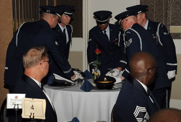 Members of the Fairchild Honor Guard render reverence in memory of United States armed forces fallen, missing, or imprisoned military service members during the 67th Air Force Ball at the Red Lion Hotel in Spokane, Washington, Sept. 6, 2014. This ceremony has a variety of symbolic elements to portray aspects such as families’ tears as they wait, the purity of the service member’s intentions to respond to their country's call to arms, and a representation of those who have not returned from war and the trials of these missing veterans. (U.S. Air Force photo by Staff Sgt. Samantha Krolikowski/Released)