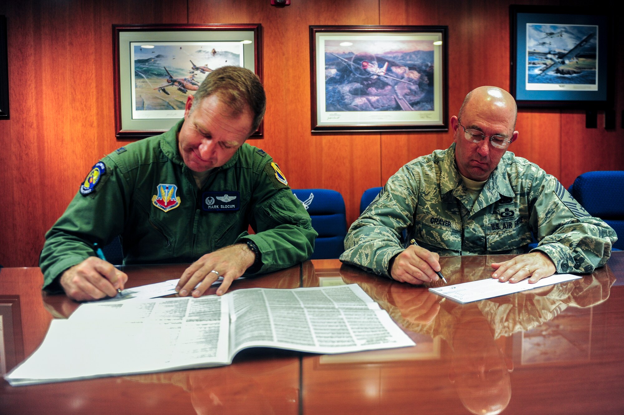 Col. Mark Slocum, 4th Fighter Wing commander, and Chief Master Sgt. Jeffrey Craver, 4th FW command chief, sign their pledge forms to kick off the annual Combined Federal Campaign on Aug. 28, 2014 at Seymour Johnson Air Force Base, North Carolina. The CFC provides members of Team Seymour the opportunity to donate to more than 20,000 charities. With the campaign lasting until Oct. 20, the 4th FW goal aims to raise $180,000 this year. (U.S. Air Force photo by Airman 1st Class Brittain Crolley)