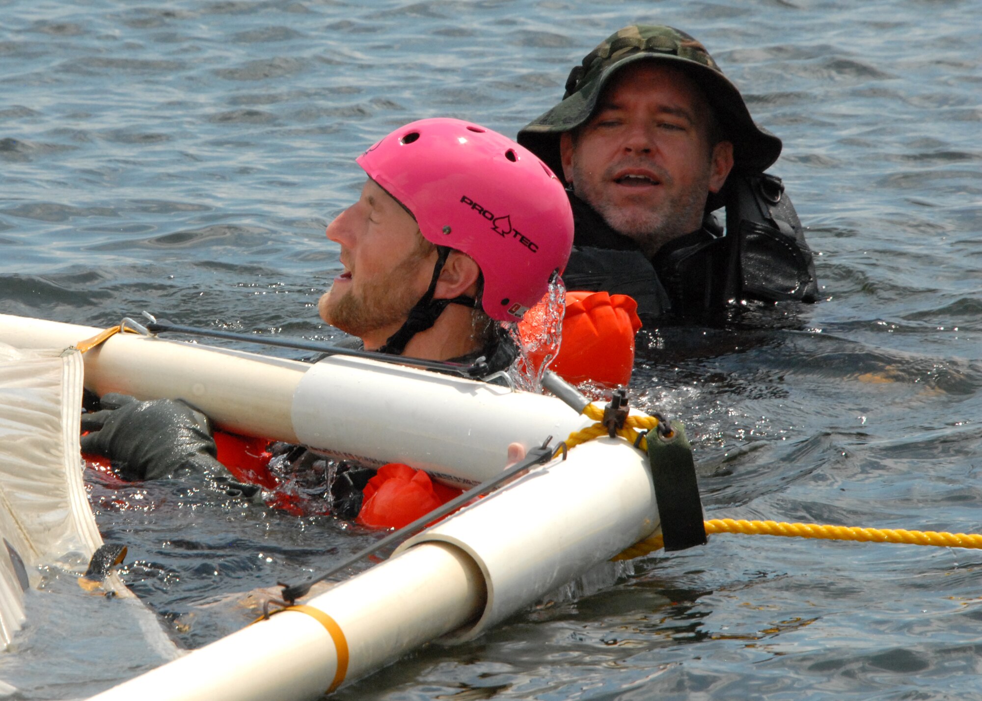 Justin Tate, 85th Test and Evaluation Squadron honorary commander, emerges from under a parachute as a safety monitor looks on, during water survival training at Post’l Point, Sept. 5 at Eglin Air Force Base, Fla.  The water survival training offered an interactive environment for community members to better understand what pilots do in the event of an emergency landing at sea.  The honorary commander program pairs civic leaders and wing leadership together to exchange ideas and educate civilians about Air Force life. (U.S. Air Force photo/Kevin Gaddie)