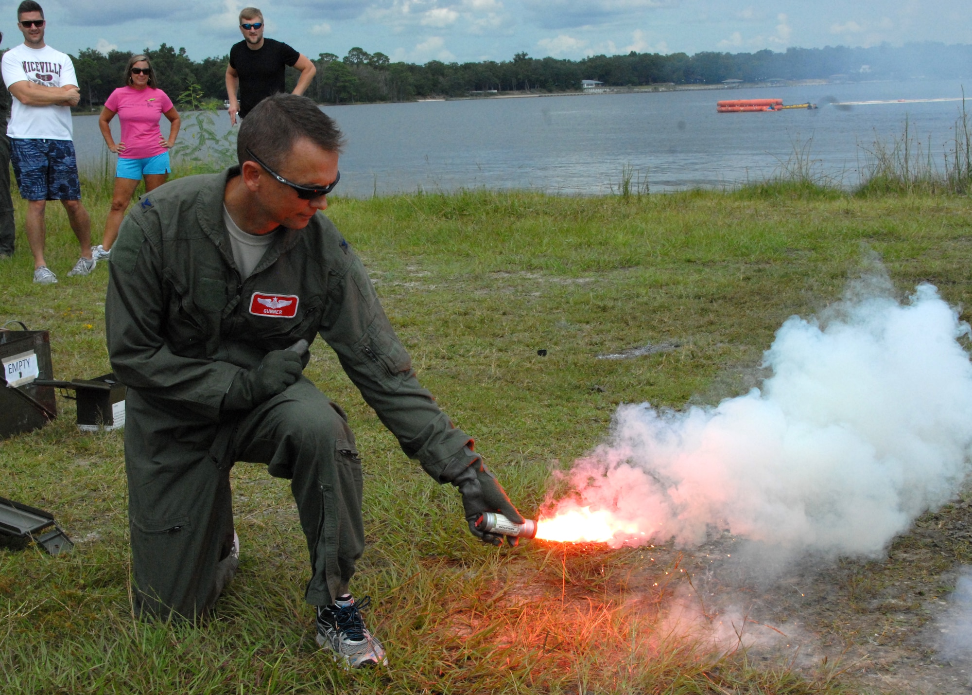 Col. Scott Thompson, 96th Operations Group commander, ignites a flare as honorary commanders look on during water survival training at Post’l Point, Sept. 5 at Eglin Air Force Base, Fla.  The water survival training offered an interactive environment for community members to better understand what pilots may face in the event of an emergency landing over the sea.  The honorary commander program pairs civic leaders and wing leadership together to exchange ideas and educate civilians about Air Force life. (U.S. Air Force photo/Kevin Gaddie)