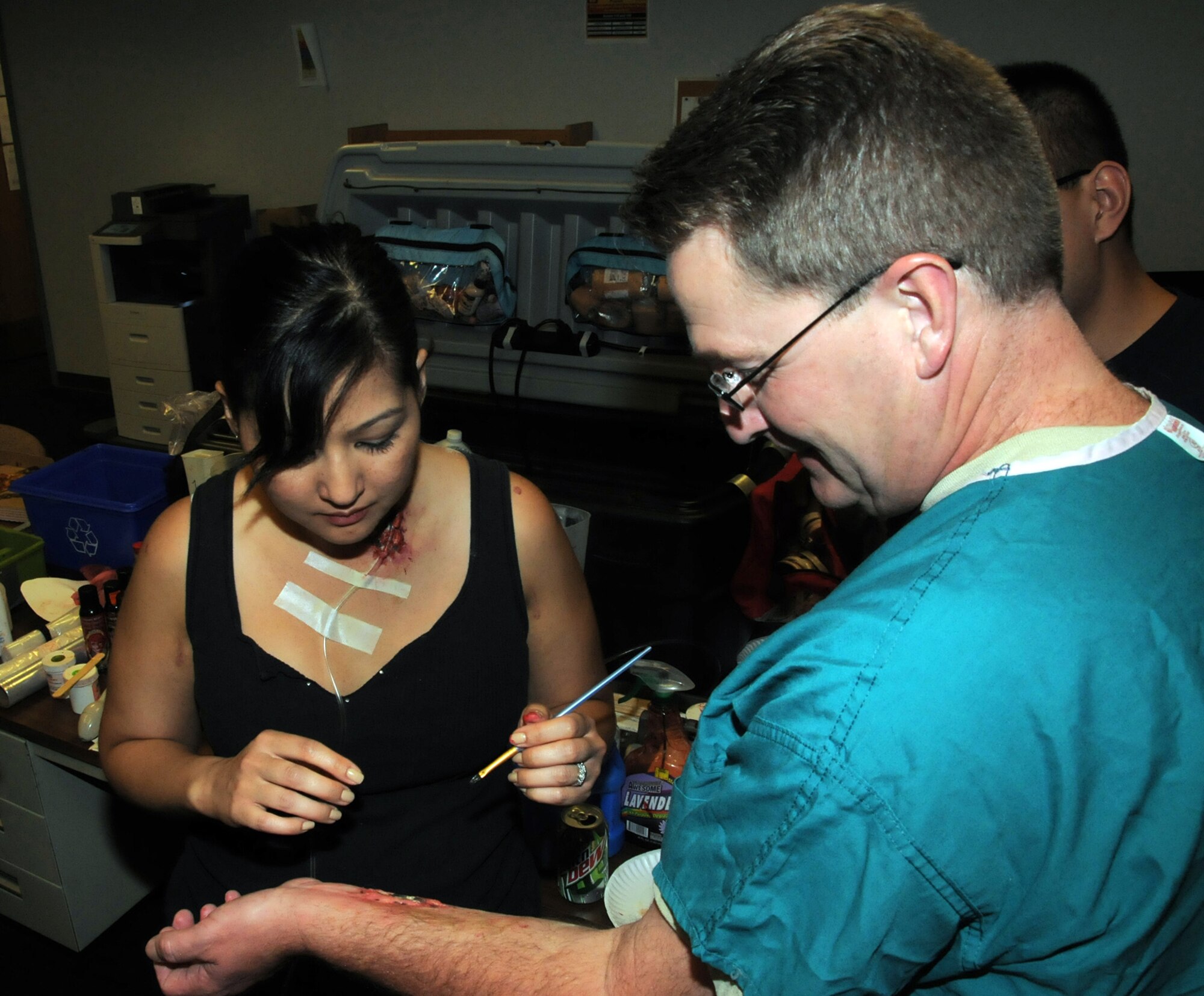 WRIGHT PATTERSON AIR FORCE BASE, Ohio – Master Sgt. Julie Turner applies moulage to Master Sgt. Todd Noe’s arm to simulate an arm wound. Both are assigned to the 445th Aerospace Medicine Squadron. Moulage is used to create realistic wounds during a mass casualty training exercise, enhancing the realism of a scenario involving victims. (U.S. Air Force photo/Tech. Sgt. Anthony Springer)