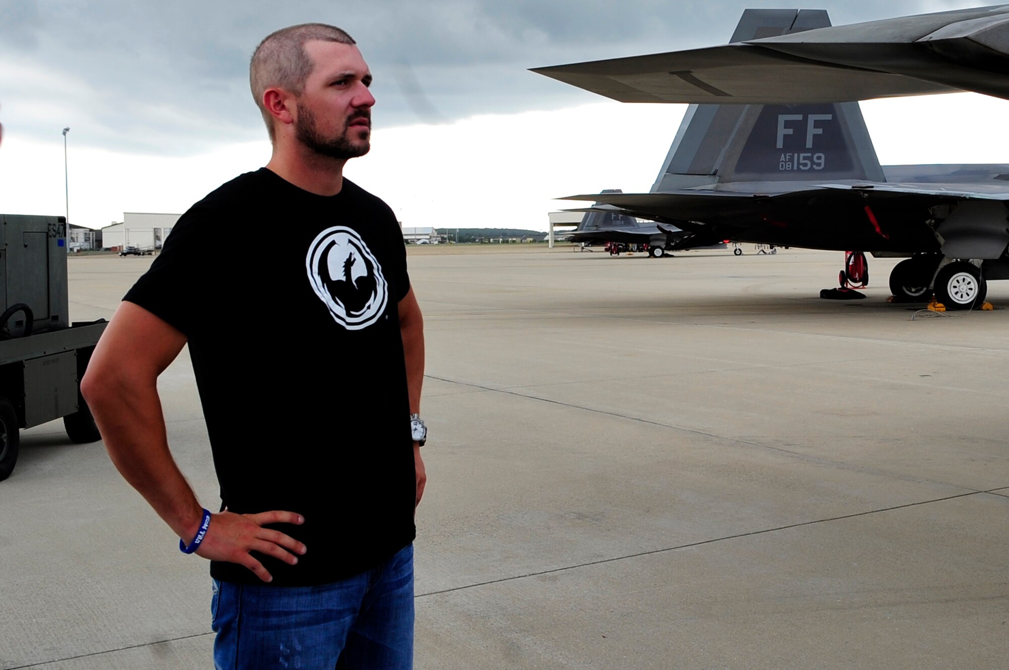 Michael Annett, NASCAR driver, looks at an F-22 Raptor during his visit to Langley Air Force Base, Va., Sept. 4, 2014. Annett said while on his tour, he learned the size of the base is bigger than he imagined, compared to other Air Force bases - Langley is like its own city. (U.S. Air Force photo by Airman 1st Class Breonna Veal/Released)  (Photo was cropped and color corrected to emphasize subject.)