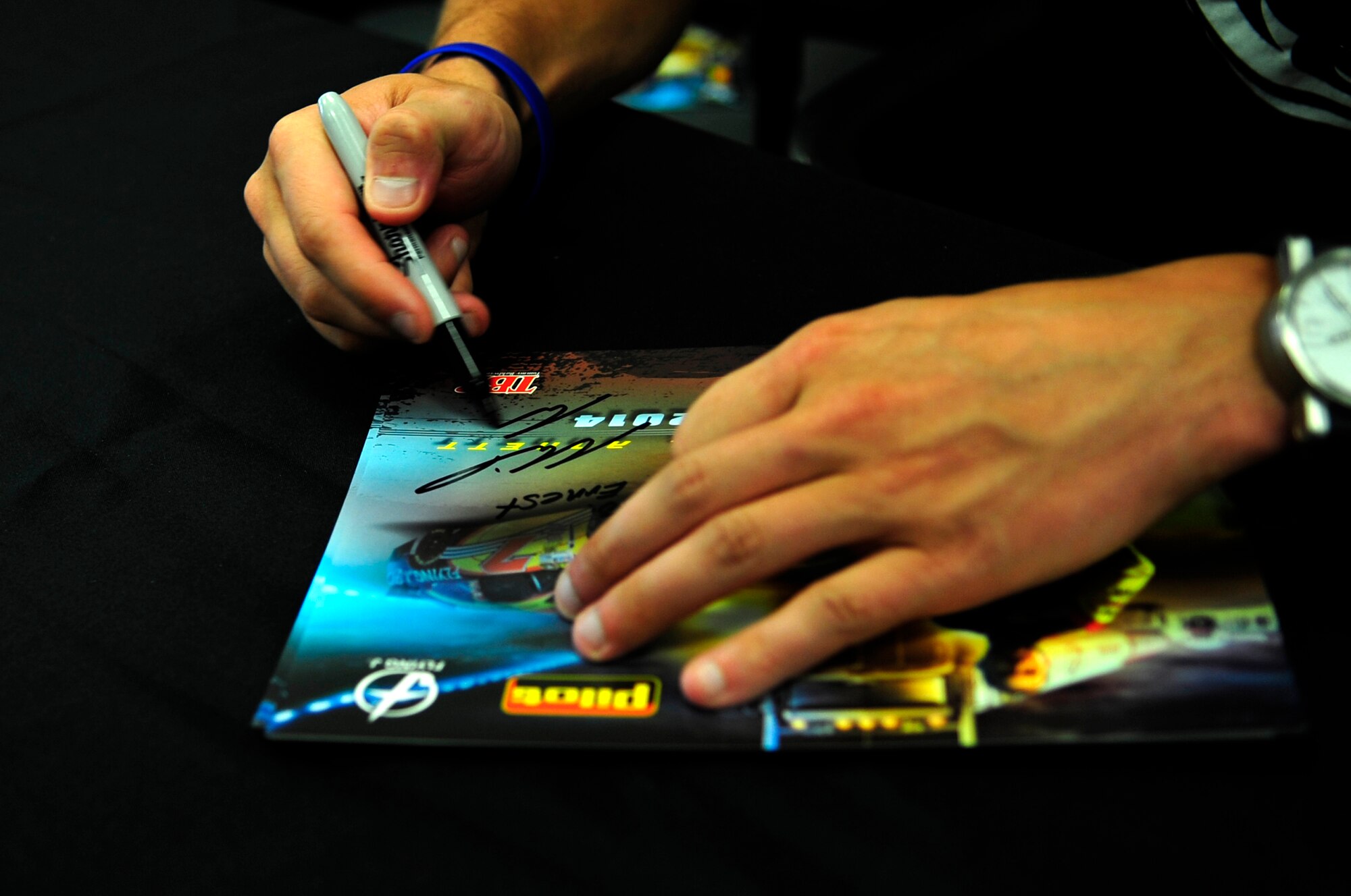 Michael Annett, NASCAR driver, signs his autograph on a picture at the Exchange on Langley Air Force Base, Va., Sept. 4, 2014. According to Annett, he wouldn’t be able to do what he does without the service of military members protecting his freedom. (U.S. Air Force photo by Airman 1st Class Breonna Veal/Released) (Photo was cropped and color corrected to emphasize subject.)