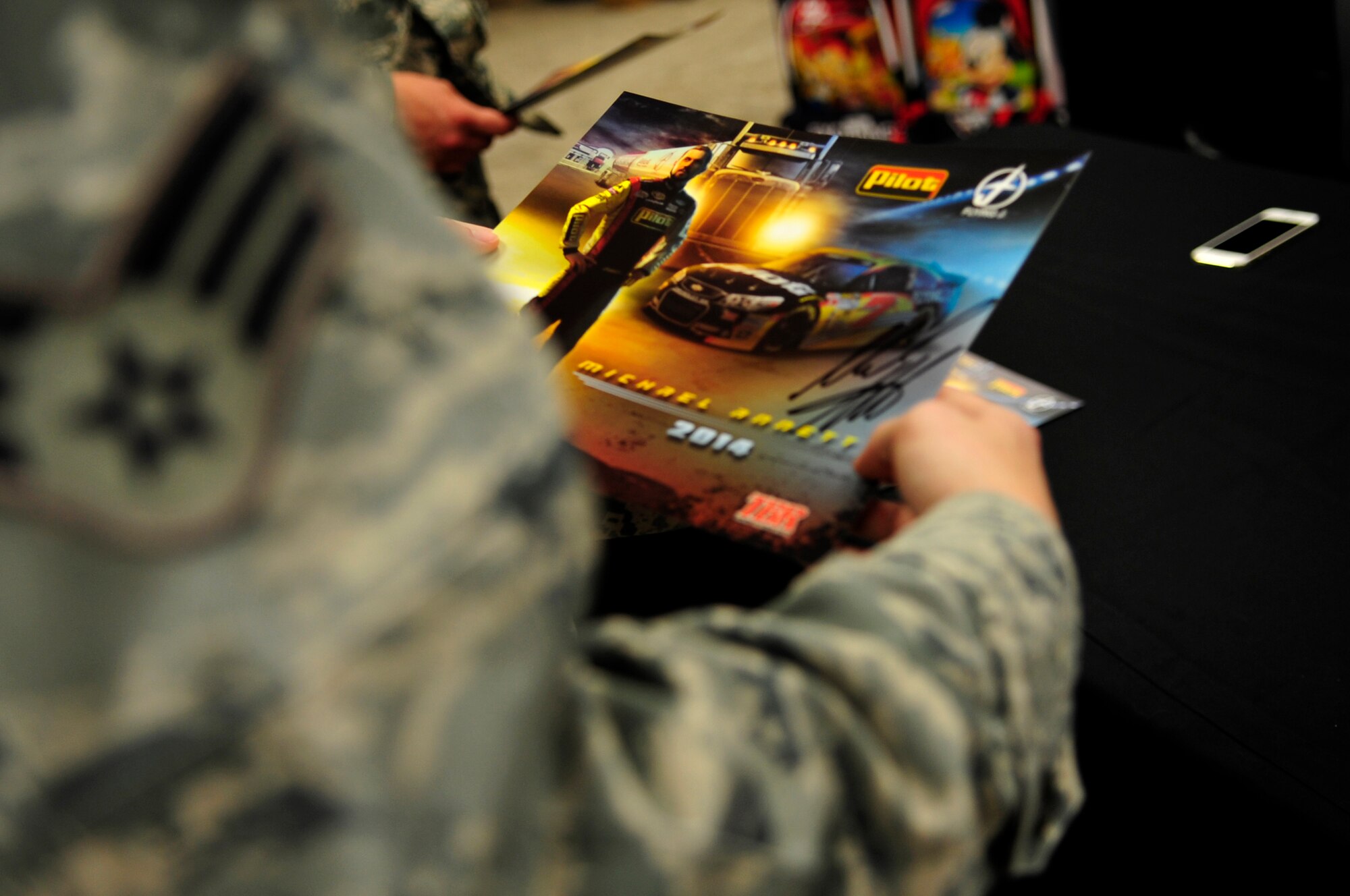 A U.S. Air Force Airman holds a signed photo of Michael Annett, NASCAR driver, during an autograph signing at the Exchange on Langley Air Force Base, Va., Sept. 4, 2014. Annett said he wanted to visit Langley after hearing about the history of the base. (U.S. Air Force photo by Airman 1st Class Breonna Veal/Released) (Photo was cropped and color corrected to emphasize subject.)
