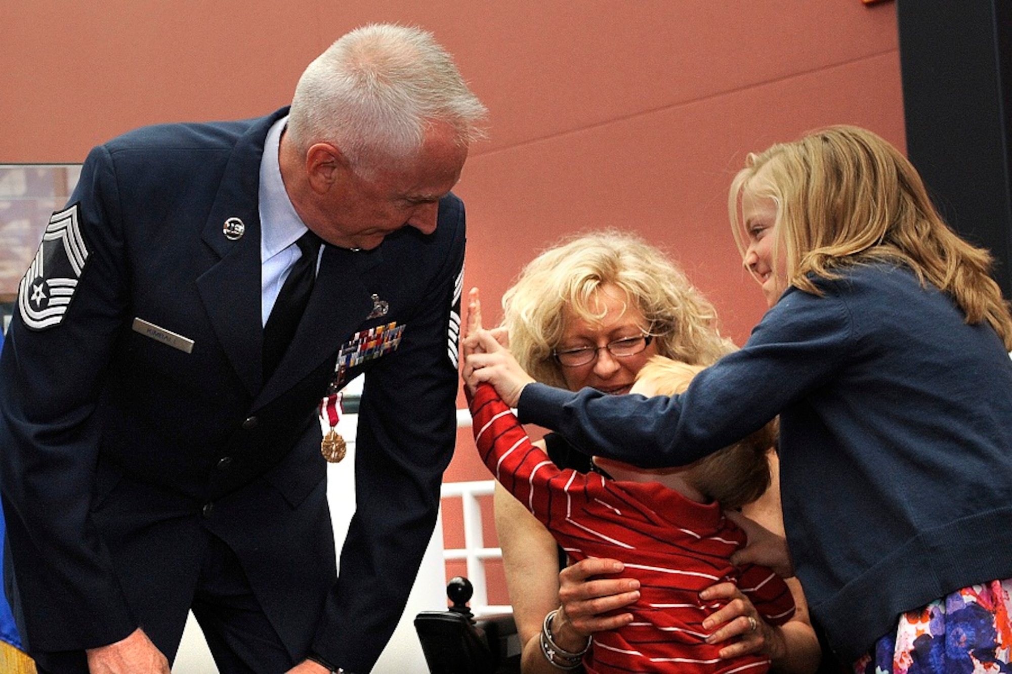 A family of warriors gathered together June 19 at Peterson Air Force Base, Colo., to promote Air Force Reserve Senior Master Sgt. Thomas W. Kimball to chief master sergeant. Megan helps her brother Jack, named for the chief's father, punch stripes on their grandfather. (U.S. Air Force photo/Duncan Wood)