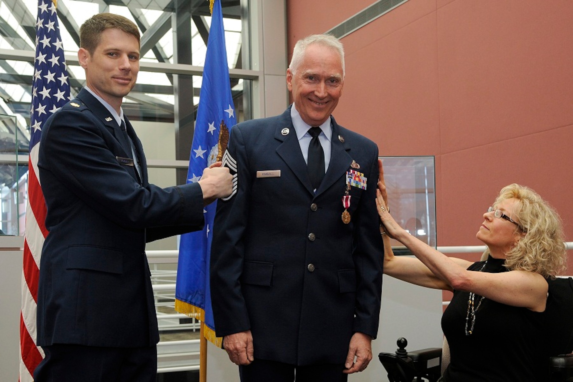 A family of warriors gathered together June 19 at Peterson Air Force Base, Colo., to promote Air Force Reserve Senior Master Sgt. Thomas W. Kimball to chief master sergeant. Maj. Mark E. Kimball, chief's nephew, and Tracey Kimball, chief's wife, punch stripes onto the promotee during the ceremony. (U.S. Air Force photo/Duncan Wood)