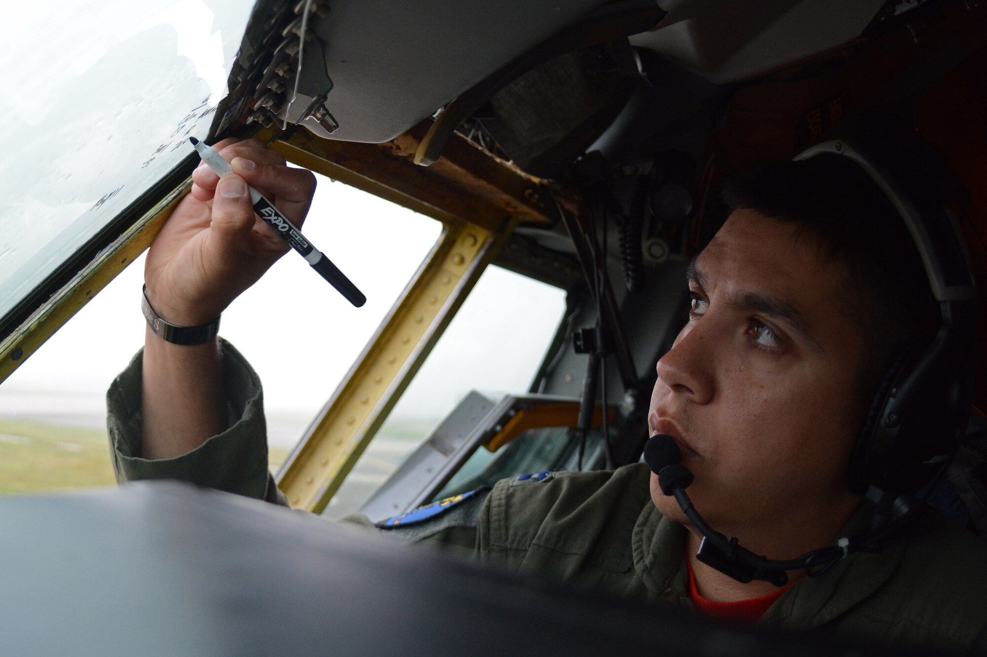 U.S. Air Force Capt. Steve Briones, 351st Air Refueling Squadron copilot from El Paso, Texas, writes current weather information on a window of a KC-135 Stratotanker Sept. 5, 2014, on RAF Mildenhall, England. The information is entered into the automated terminal information system which helps aircrew determine whether the aircraft can take-off and provides specifics about how the aircraft needs to take off. (U.S. Air Force photo/Senior Airman Micaiah Anthony/Released)