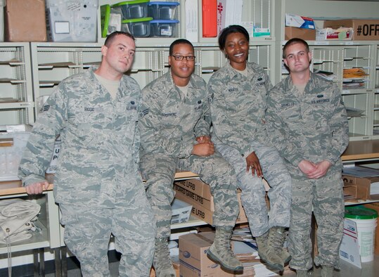(From left to right) Senior Airman Michael Riggio, Senior Airman Tommy Armstrong, Airman 1st Class Jahkilyah Minatee and Airman 1st Class Allen Spangler, all from the 60th Communications Squadron, pose for a group photo Aug. 26, 2014, in the Official Mail Center. (U.S. Air Force photo by Senior Airman Charles Rivezzo)