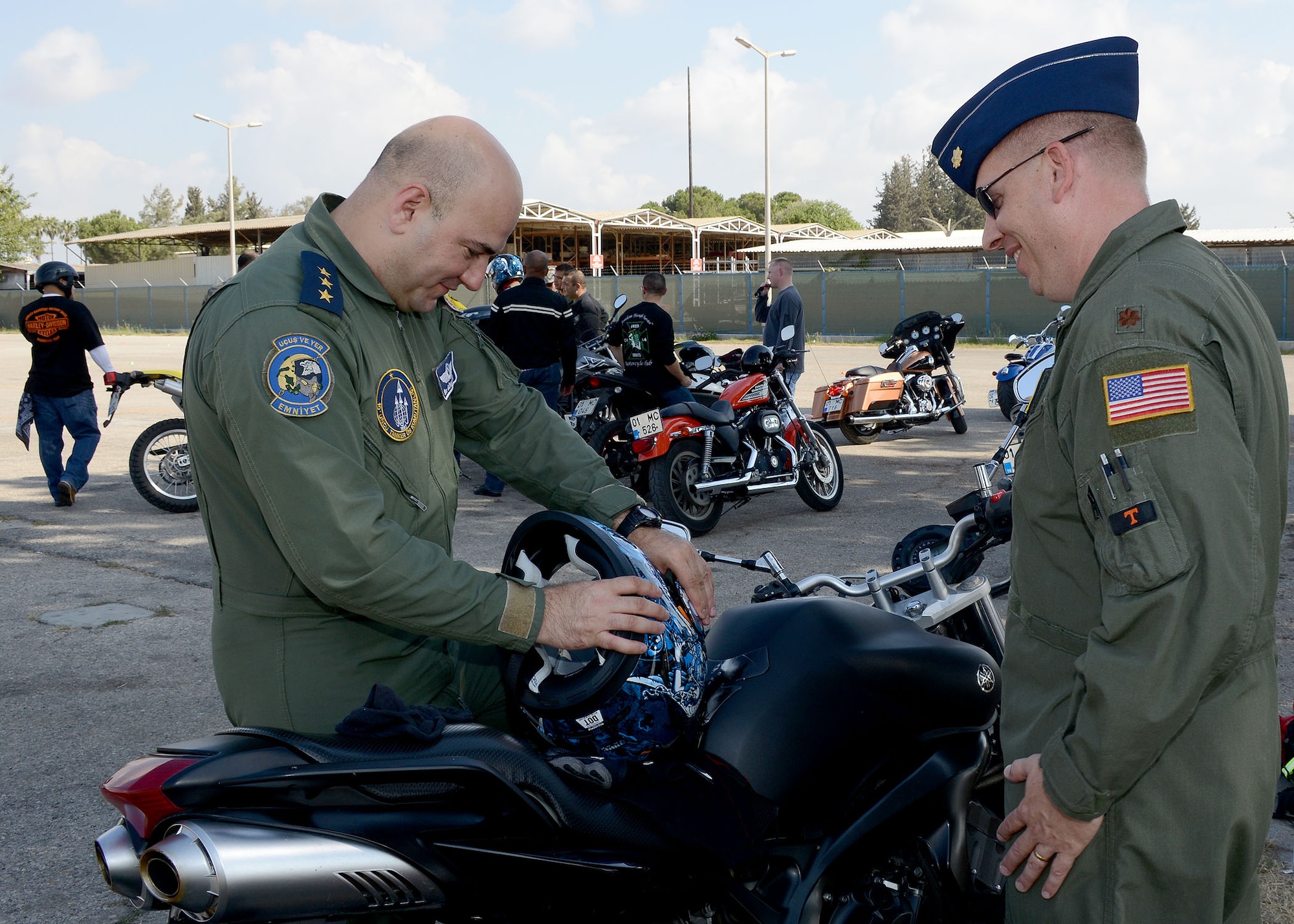 Turkish air force Capt. Ilke Gonenden, 10th Tanker Base, and Maj. Jason Helton, 39th Air Base Wing chief of safety, talk about Gonenden’s motorcycle safety gear Sept. 5, 2014, Incirlik Air Base, Turkey. A joint motorcycle safety course was provided by the 39th ABW safety office. The exercises demonstrate how to improve motorcycle control in limited space, and to improve the ability to avoid hazards. (U.S. Air Force photo by Staff Sgt. Veronica Pierce/Released)