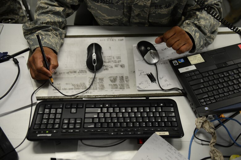 U.S. Air Force Capt. Romaine Russell, 606th Air Control Squadron bravo flight commander and native of Baltimore, documents coordinates of aircraft during a simulation inside a battle-space command control center Aug. 18, 2014 at Spangdahlem Air Base, Germany. The training program consisted of 3,000 total man hours of academics, tests and simulations, including 100 simulated hours of maximum capacity aircraft representing the deployed environment supporting Operation Enduring Freedom. (U.S. Air Force photo by Senior Airman Gustavo Castillo/Released)