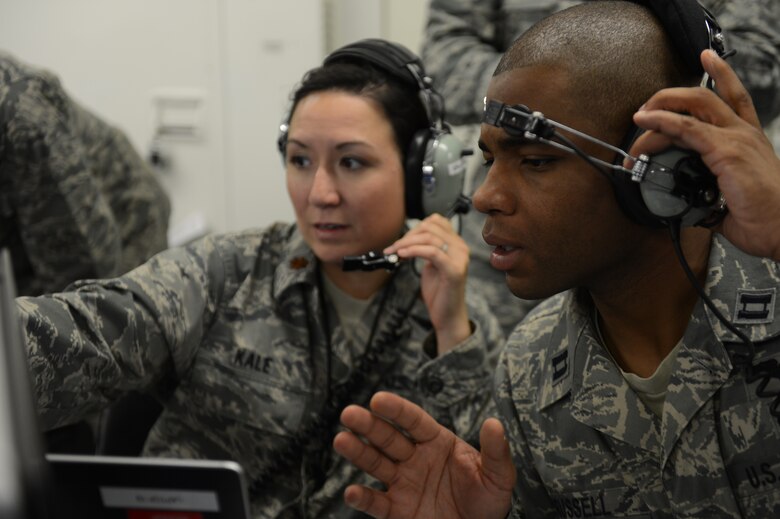 U.S. Air Force Maj. Carol Kale, 606th Air Control Squadron assistant director of operations and native of Fort Worth, Texas, left, and U.S. Air Force Capt. Romaine Russell, 606th ACS bravo flight commander and native of Baltimore, relay information during a simulation inside a battle-space command control center Aug. 18, 2014 at Spangdahlem Air Base, Germany. These operators maintain a real-time picture of the area of operations while communicating with air and ground assets. The constant training 606th ACS Airmen undergo allows them to be ready to deploy at a moment’s notice. (U.S. Air Force photo by Senior Airman Gustavo Castillo/Released)