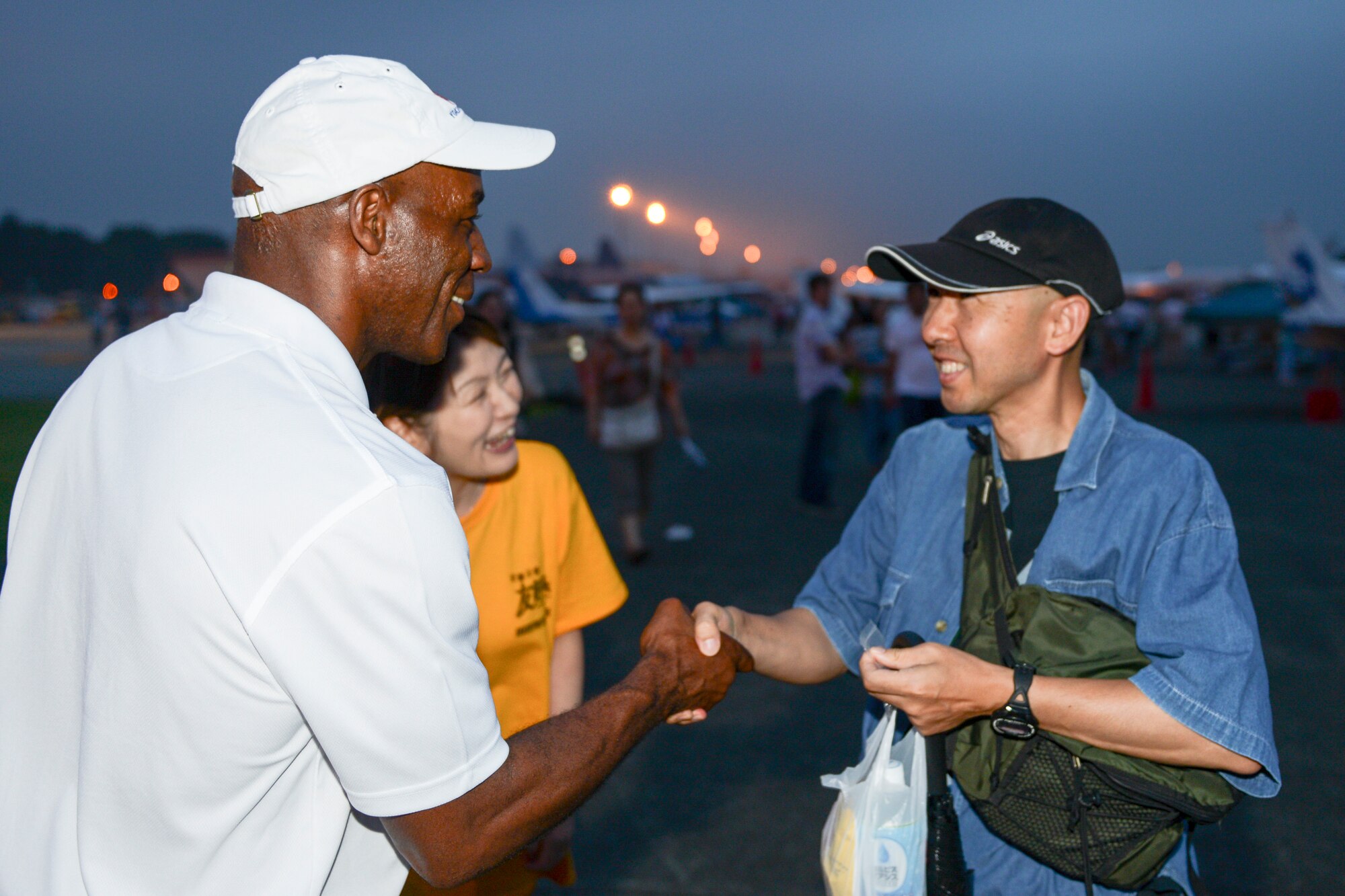 Col. Clarence Lukes, 374th Airlift Wing vice commander, offers a unit coin to a man during the 2014 Japanese-American Friendship Festival at Yokota Air Base, Japan, Sept. 6, 2014. (U.S. Air Force photo by Staff Sgt. Cody H. Ramirez/Released)