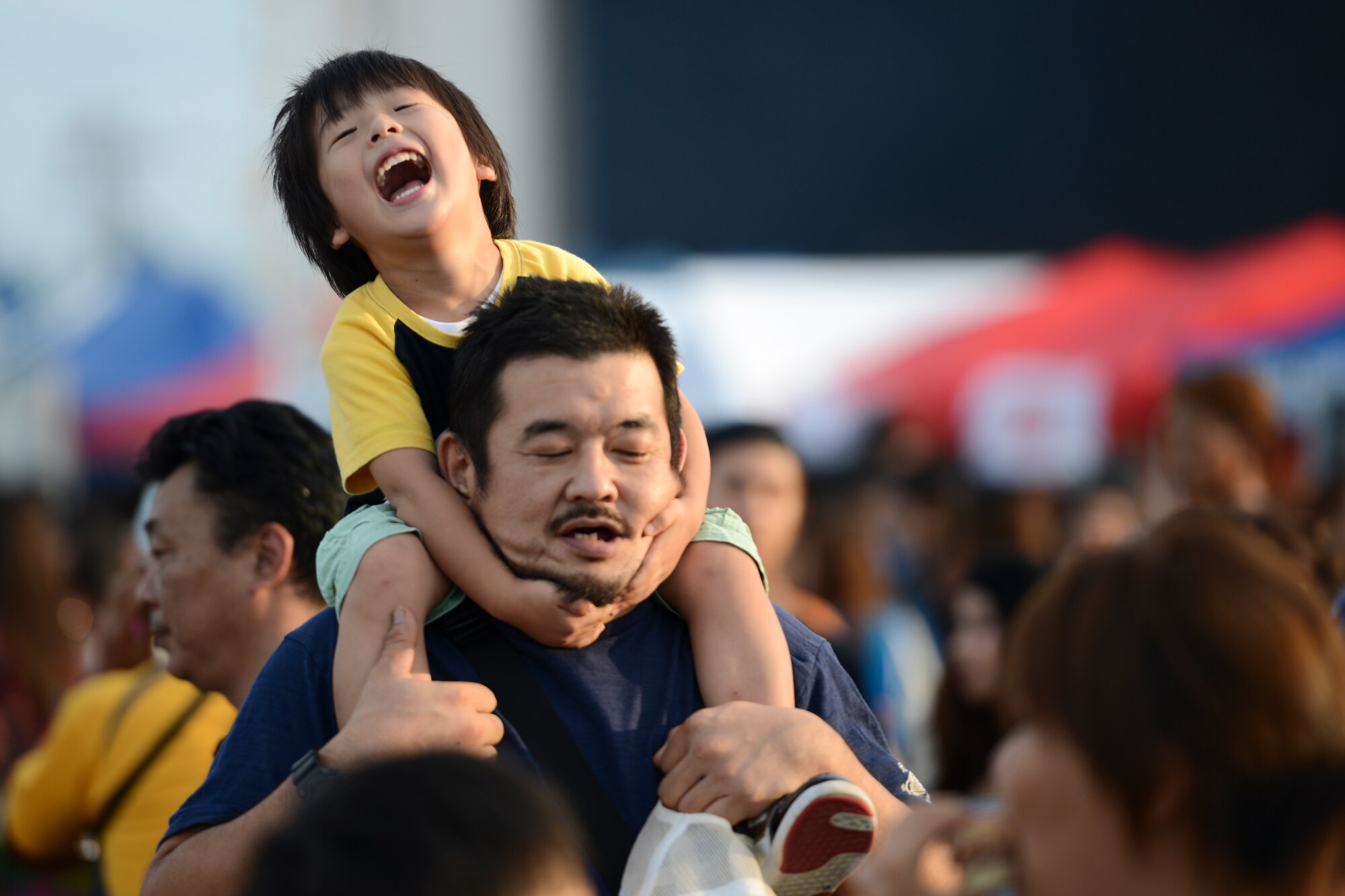 A boy plays with his father during the 2014 Japanese-American Friendship Festival at Yokota Air Base, Japan, Sept. 7, 2014. Yokota, with an average populace of 11,000 people, hosted more than 148,000 during the two-day festival. (U.S. Air Force photo by Staff. Sgt. Cody H. Ramirez/Released)