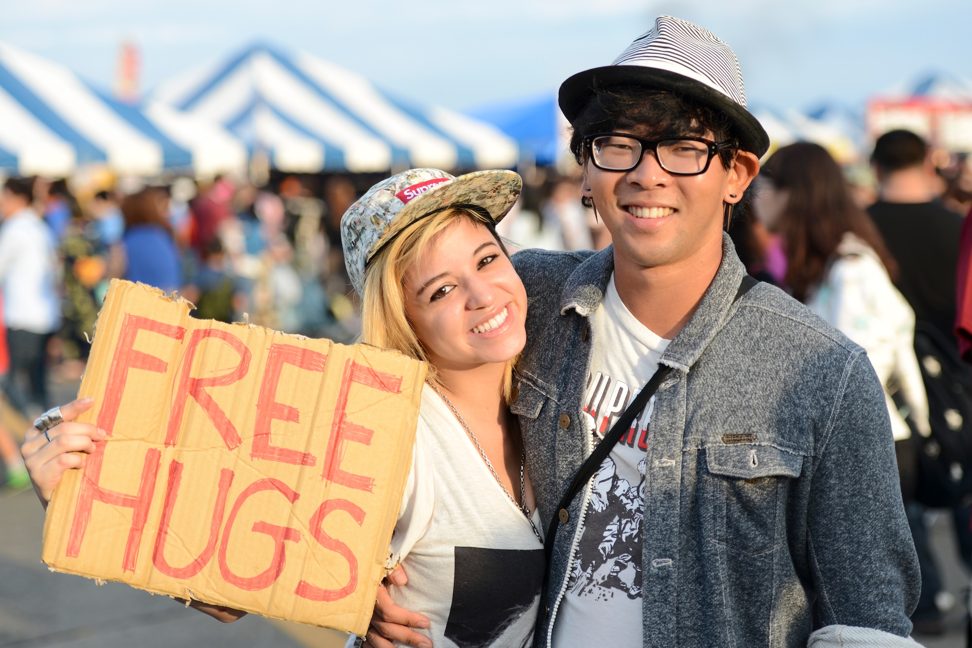 A woman holds a sign while giving out hugs during the 2014 Japanese-American Friendship Festival at Yokota Air Base, Japan, Sept 7, 2014. The festival provided the more than 148,000 attendees a chance to see a variety of U.S. and Japanese military aircraft and explore cultural ties such as food and live performances. (U.S. Air Force photo by Staff Sgt. Cody H. Ramirez/Released)