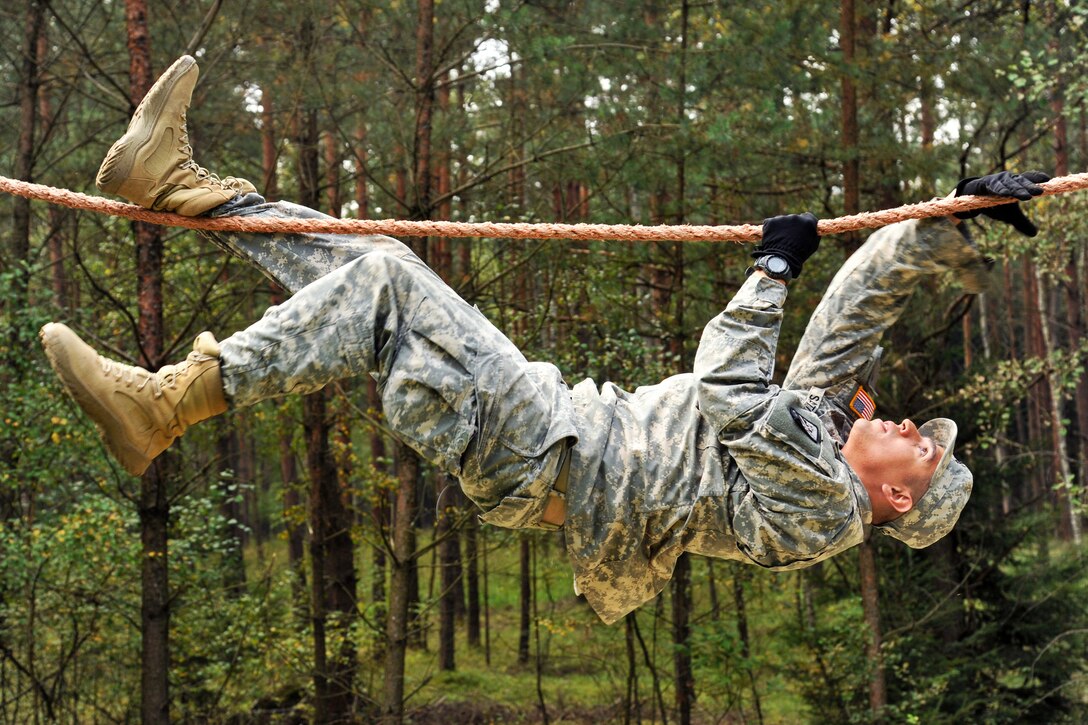 U.S. Army Sgt. Salvador Santos negotiates the rope bridge during obstacle course training at the 7th Army Joint Multinational Training Command's Grafenwoehr Training Area, Germany, Sept. 4, 2014. Santos is assigned to Headquarters Company, 18th Combat Sustainment Support Battalion.
