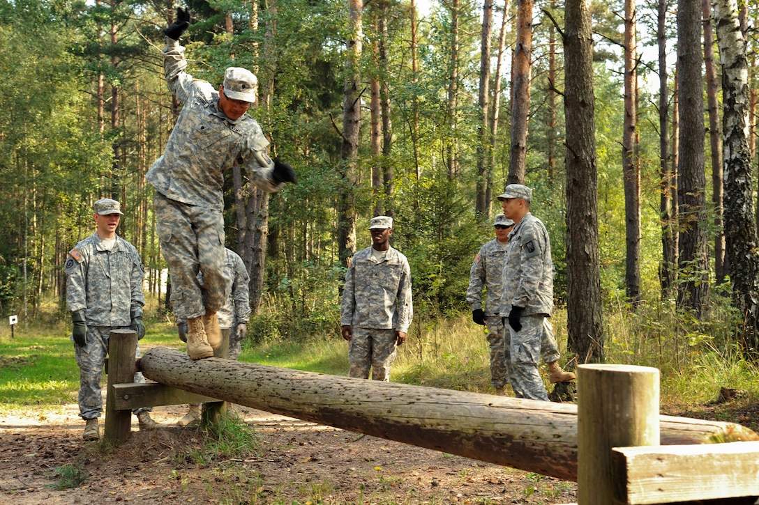 U.S. Army Spc. Michael Merino balances on a log during obstacle course training at the 7th Army Joint Multinational Training Command's Grafenwoehr Training Area, Germany, Sept. 4, 2014. Merino is assigned to Headquarters Company, 18th Combat Sustainment Support Battalion.