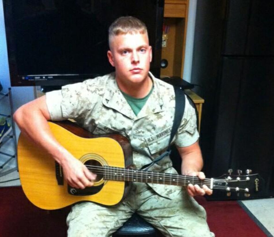 Lance Cpl. Josh Wiggins poses for a photo while playing his guitar. 