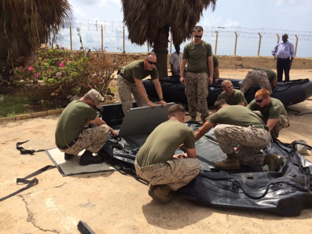 Marines and Coastguardsmen with Special-Purpose Marine Air-Ground Task Force Africa 14 assemble a zodiac combat reconnaissance rubber craft prior to conducting small-boat operations with Senegalese Companie de Fusilier Marine Commandos (COFUMACO) in Toubacouta, Senegal, Aug. 25, 2014.  Marines and Sailors with SP-MAGTF Africa 14 have teamed with the U.S. Coast Guard for upcoming theater security cooperation engagements in Africa. (Courtesy Photo)