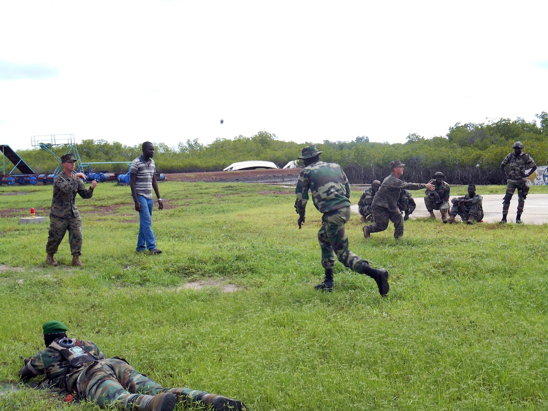 Sgt. Richard Flavell, (left), and Lance Cpl. Michael Ciavirella (right rear), lead the Senegalese Companie de Fusilier Marine Commandos, or COFUMACO, in a fire and movement drill in Toubacouta, Senegal, Aug. 28, 2014. During the drill, the man bounding has to catch a ball and throw it back, forcing him to maintain situational awareness while bounding. The drill was part of a joint training engagement between U.S. Marines, Coast Guard, and the COFUMACO. (Courtesy Photo by Lance Cpl. Jonathan Neumann)