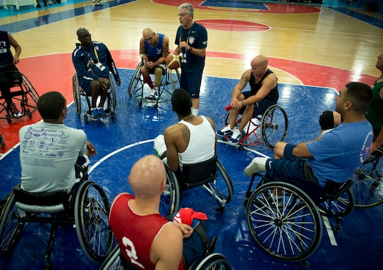 Grant Moorhead, the U.S. team's wheelchair basketball coach, gives instructions to the players during practice for the first Invictus Games Sept. 8, 2014, in London. Wounded warriors from the U.S. and 13 other nations came together here Sept. 8 to participate in their first team training for the paralympic-style events, including swimming, track and field, seated volleyball, wheelchair basketball, and wheelchair rugby, among others.(U.S. Air Force photo/Staff Sgt. Andrew Lee)