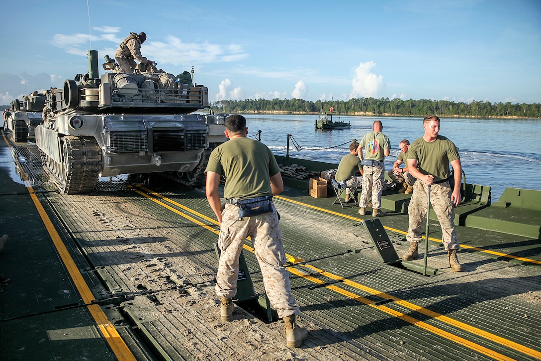 Marines with Bridge Company, 8th Engineer Support Battalion, 2nd Marine Logistics Group, use levers to raise the rear ramp after picking up two M1A1 Abrams tanks from 2nd Tank Battalion, 2nd Marine Division, to cross New River aboard Marine Corps Base Camp Lejeune, N.C., Sept. 4, 2014. During the training exercise, the Marines transported 22 tanks across the river, totaling approximately 1,540 tons. (U.S. Marine Corps photo taken by Lance Cpl. Alex W. Mitchell/released)