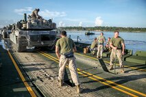 Marines with Bridge Company, 8th Engineer Support Battalion, 2nd Marine Logistics Group, use levers to raise the rear ramp after picking up two M1A1 Abrams tanks from 2nd Tank Battalion, 2nd Marine Division, to cross New River aboard Marine Corps Base Camp Lejeune, N.C., Sept. 4, 2014. During the training exercise, the Marines transported 22 tanks across the river, totaling approximately 1,540 tons. (U.S. Marine Corps photo taken by Lance Cpl. Alex W. Mitchell/released)