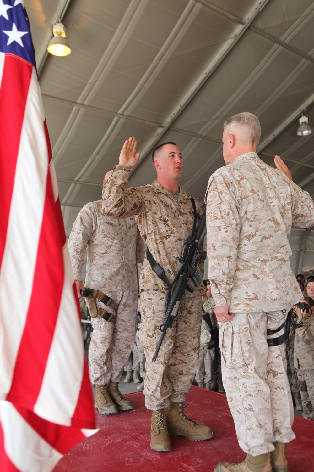 Corporal William Gelroth, left, a radio repair technician with Intermediate Maintenance Activity Platoon, Combat Logistics Battalion 1, is administered his oath of enlistment by Gen. James F. Amos, the 35th Commandant of the Marine Corps, following his meritorious promotion ceremony aboard Camp Leatherneck, Afghanistan, Sept. 6, 2014. Gen. Amos meritoriously promoted Gelroth, a native of Louviers, Colo., to the rank of corporal during his final visit to Helmand province.