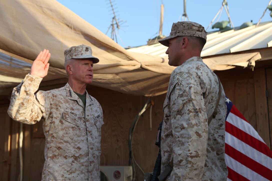Gen. James F. Amos, the 35th Commandant of the Marine Corps, administers the oath of enlistment to Sgt. Dominic Sharpsteensurina, an assault section leader with Charley Company, 1st Battalion, 7th Marine Regiment, following his meritorious promotion ceremony aboard Camp Leatherneck, Afghanistan, Sept. 6, 2014. Gen. Amos meritoriously promoted Sharpsteensurina, a native of Minneapolis, to the rank of sergeant during his final visit to Helmand province.
