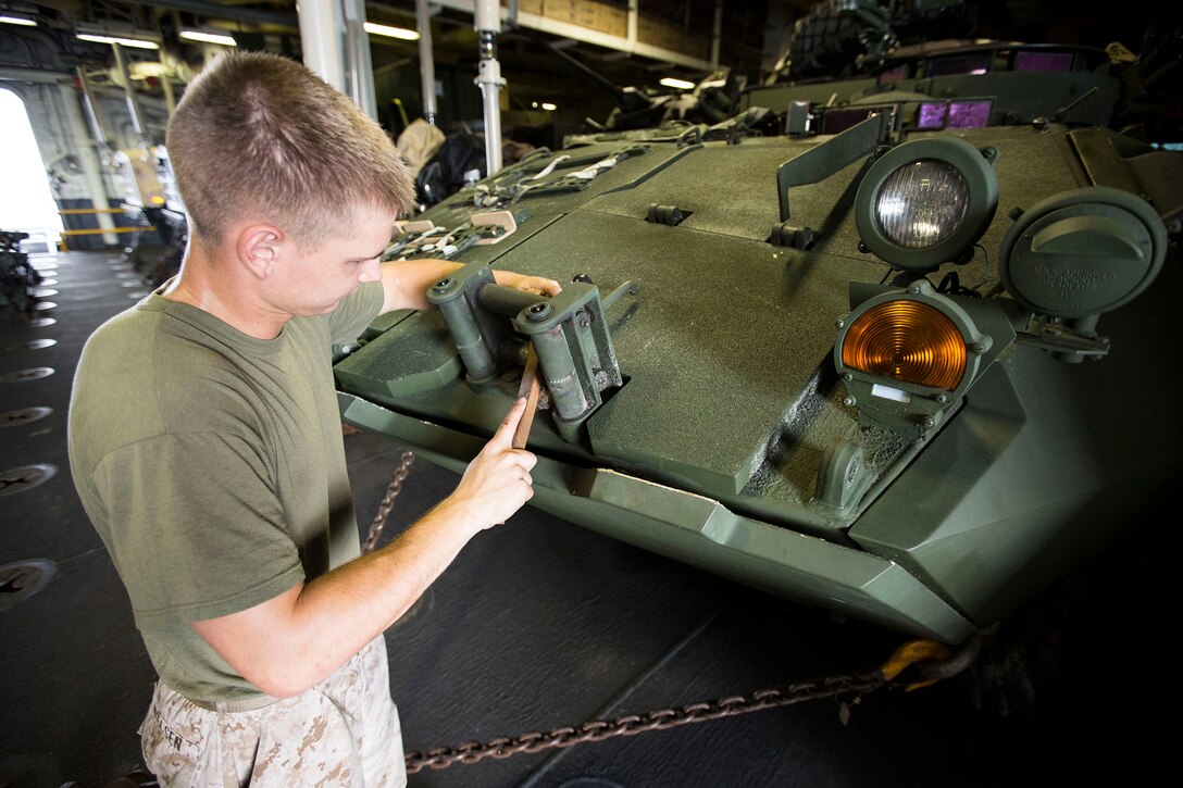 Cpl. Timothy J. Nielsen, a Light Armored Vehicle mechanic with Light Armored Reconnaissance Detachment, Weapons Company, Battalion Landing Team 3rd Battalion, 6th Marine Regiment, 24th Marine Expeditionary Unit, and Oldsmar, Fla., native, conducts corrosion prevention on an LAV during Amphibious Ready Group/Marine Expeditionary Unit Exercise aboard the USS Iwo Jima, at sea, Sept. 9, 2014. ARG/MEU-Ex is the first at sea evaluations Expeditionary Operations Training Group is conducting and is the third major predeployment exercise in preparation of the deployment at the end of the year. (U.S. Marine Corps photo by Sgt. Devin Nichols/Released)

