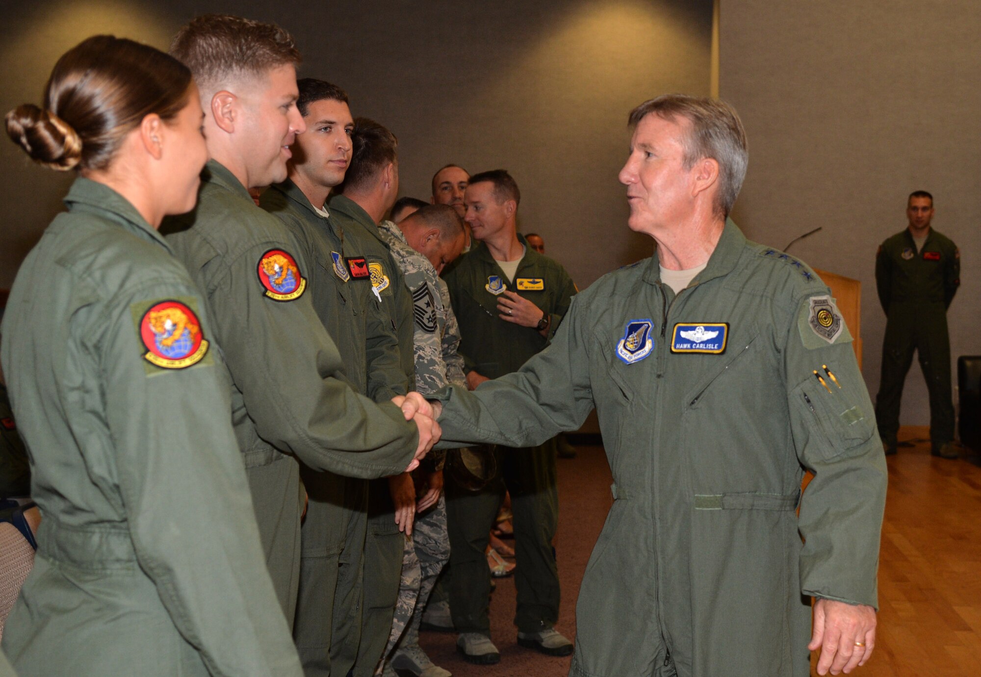 Gen. Hawk Carlisle, Pacific Air Forces commander, shakes hands with Air Force Aerial Achievement Medal recipients during a medal presentation in Hollister Auditorium at Joint Base Pearl Harbor-Hickam, Hawaii, Sept. 9, 2014. All recipients were members of two C-17 Globemaster III crews who flew humanitarian sorties in and out of the Tacloban region of the Phillipines after Typhoon Haiyan devastated the area. (U.S. Air Force photo by Staff Sgt. Alexander Martinez) 