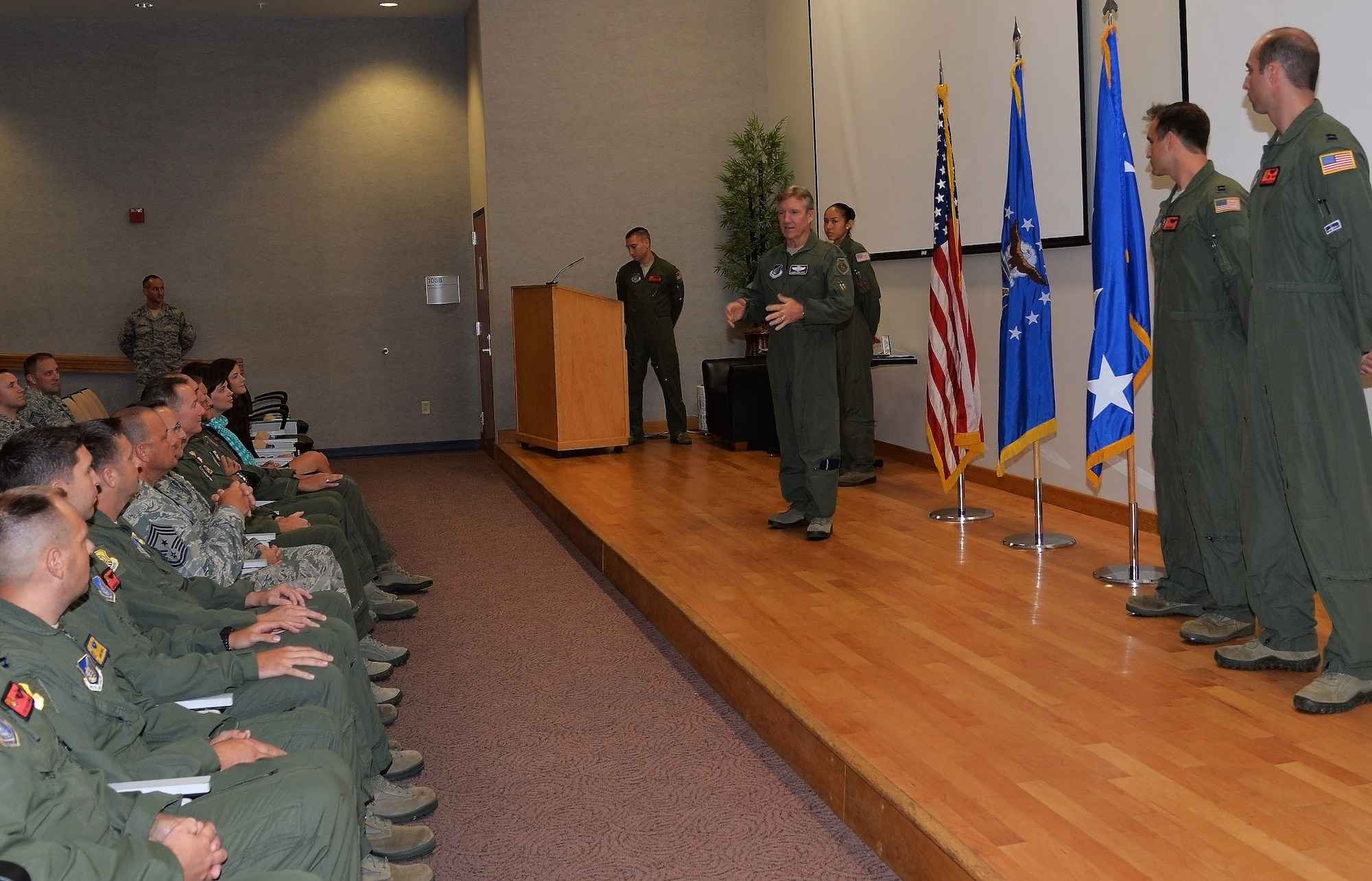 Gen. Hawk Carlisle, Pacific Air Forces commander, speaks to an audience before presenting the Air Force Aerial Achievement Medal to Captains Michael Hank and Edward Sutton, 535th Airlift Squadron, in Hollister Auditorium at Joint Base Pearl Harbor-Hickam, Hawaii, Sept. 9, 2014. Hank and Sutton were members of two C-17 Globemaster III crews who flew humanitarian sorties in and out of the Tacloban region of the Phillipines after Typhoon Haiyan devastated the area. Lt. Col. Gregg Johnson, 535th AS commander, presented five other Airmen with Air Force Aerial Achievement Medals during the presentation. (U.S. Air Force photo by Staff Sgt. Alexander Martinez) 