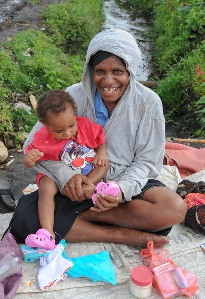 A mother smiles after receiving a new pair of shoes for her child from Master Sgt. Jamain Braxton, the anti-terrorism officer for Pacific Unity 14-8 deployed from Andersen Air Force Base, Guam.  While deployed in support of Pacific Unity, Braxton organized a shoe drive to benefit children in the local community. Pacific Unity helps cultivate common bonds and foster goodwill between the U.S. and regional nations through multilateral humanitarian assistance and civil military operations. (U.S. Air Force photo by Tech. Sgt. Terri Paden/Released)