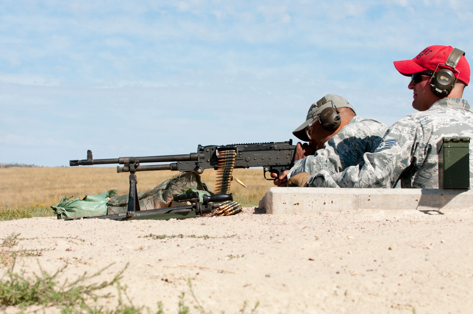 Maj. Gen. Richard Clark, Air Force Global Strike Command vice commander, fires a M240B machine gun on a long distance range on Camp Guernsey, Wyo., Sept. 4, 2014 as Staff Sgt. Brandon Layton, 620th Ground Combat Training Squadron combat arms instructor, watches on. Clark visited the camp to become familiarized with the training capabilities offered at Camp Guernsey. (U.S. Air Force photo by Lan Kim)