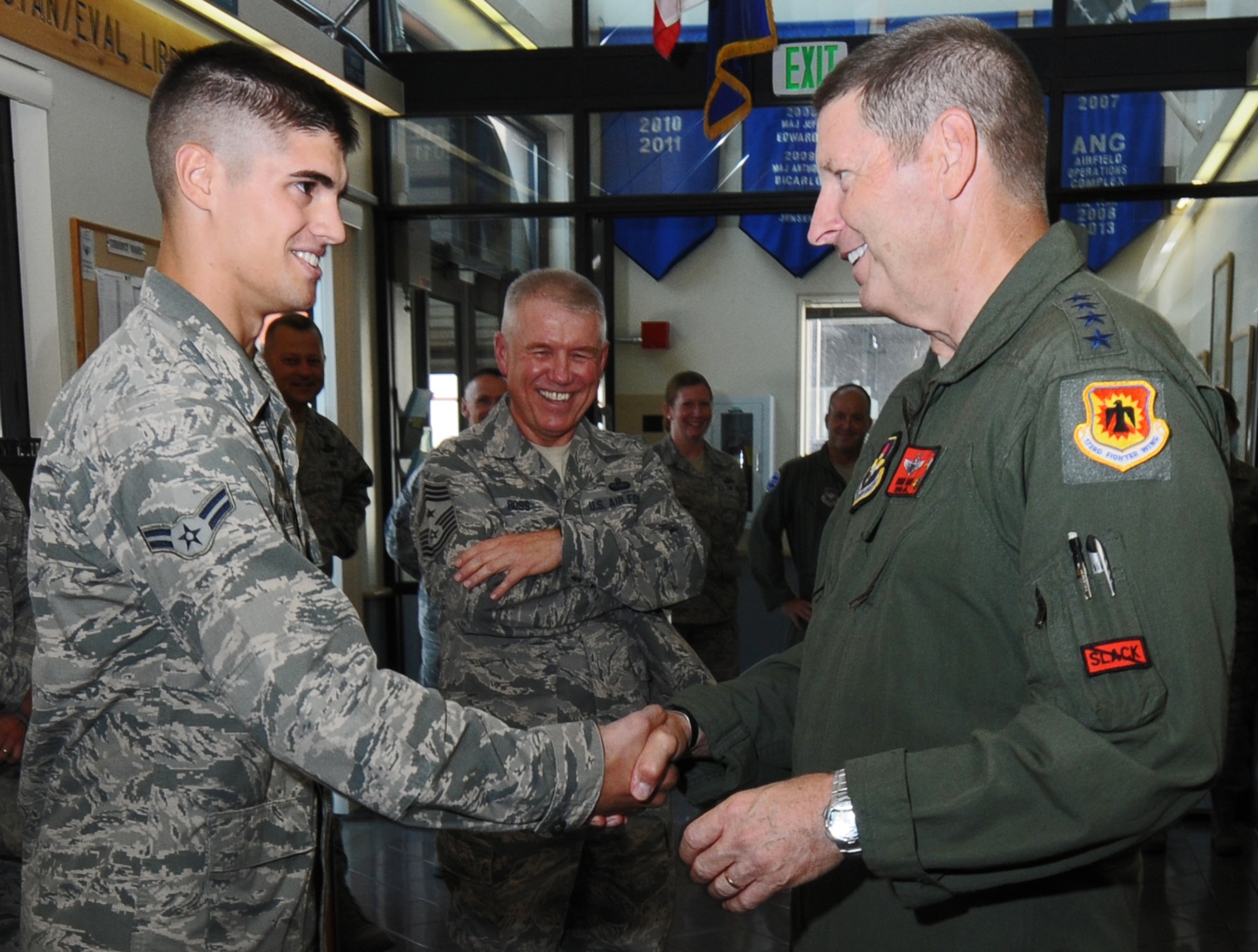 Gen. Robin Rand, commander of Air Education and Training Command, coins Airman 1st Class Zach Hamilton, 173rd Fighter Wing Aircrew Flight Equipment technician, for his outstanding performance at Kingsley Field, Klamath Falls, Ore., Aug. 27. This is Rand's first official visit to the base and serves to familiarize him with the 173 FW mission and people. (U.S. Air National Guard photo by Master Sgt. Jennifer Shirar)  