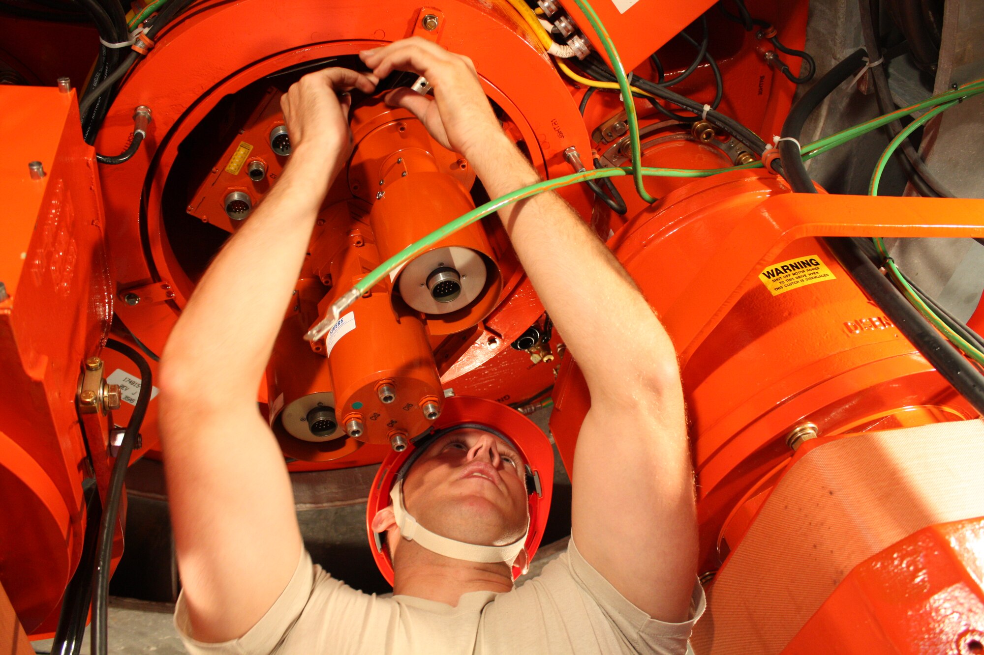 Staff Sgt. Christopher Marek, 5th Communications Squadron ground radar craftsman, removes special brackets that prevent damage to Minot Air Force Base’s digital airport surveillance system or its internal mechanics while the system spins, Aug. 25. Marek was part of a three-man team that replaced the 135-pound rotary joint, marking the first time Airmen performed such maintenance without the assistance of depot, higher-level engineers. (Official U.S. Air Force photo/Capt. Jeff M. Nagan)
