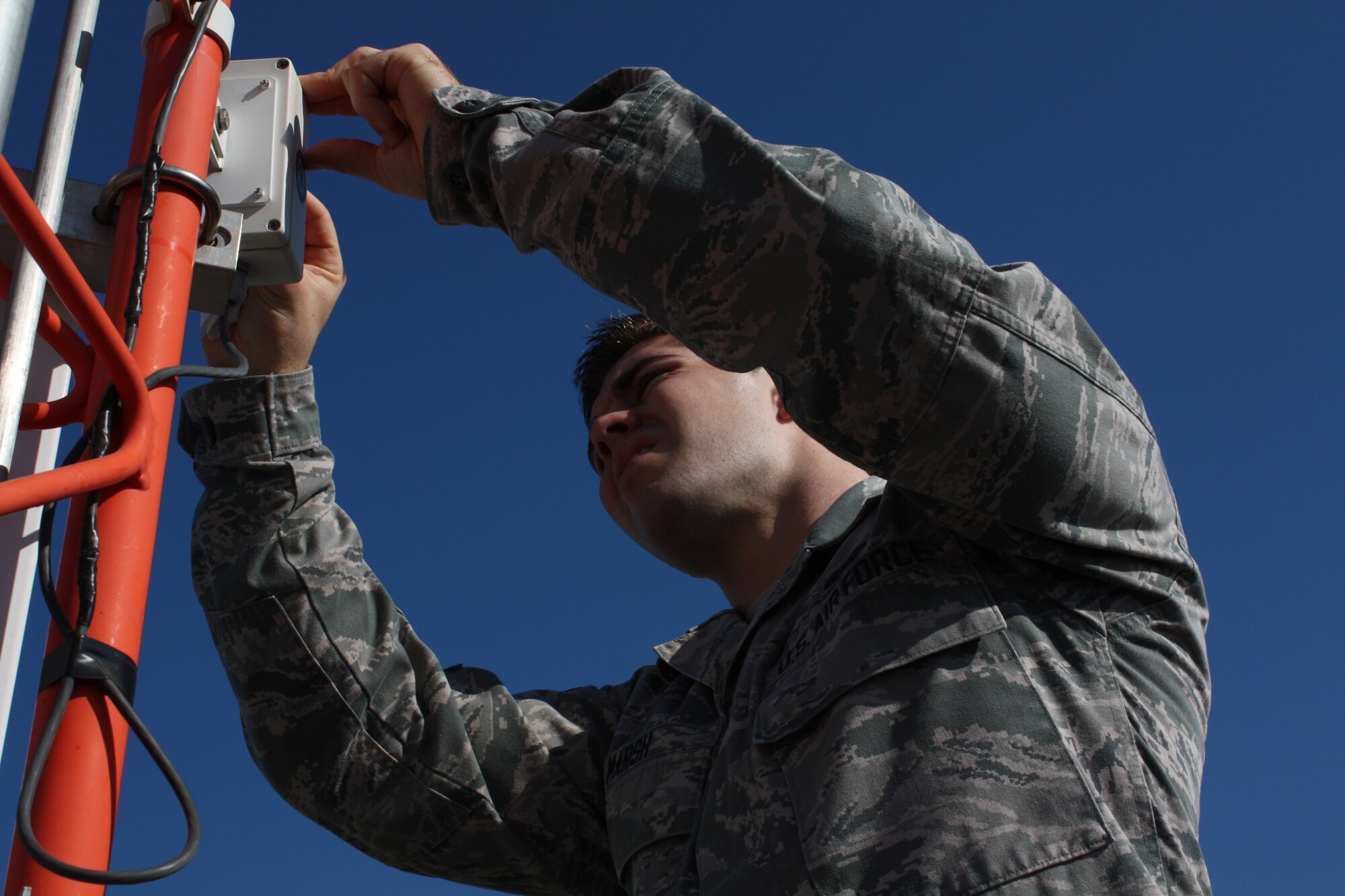 Airman 1st Class Jon R. Marsh, 5th Communications Squadron airfield systems apprentice, conducts a maintenance inspection on the FMQ-19’s ambient light sensor on Minot Air Force Base, Aug. 12. The sensor provides ambient light data to determine whether the visibility sensor should use day or night calculations. The data assists weather forecasters in assessing weather conditions for flying operations. (U.S. Air Force photo/Capt. Jeff M. Nagan) 