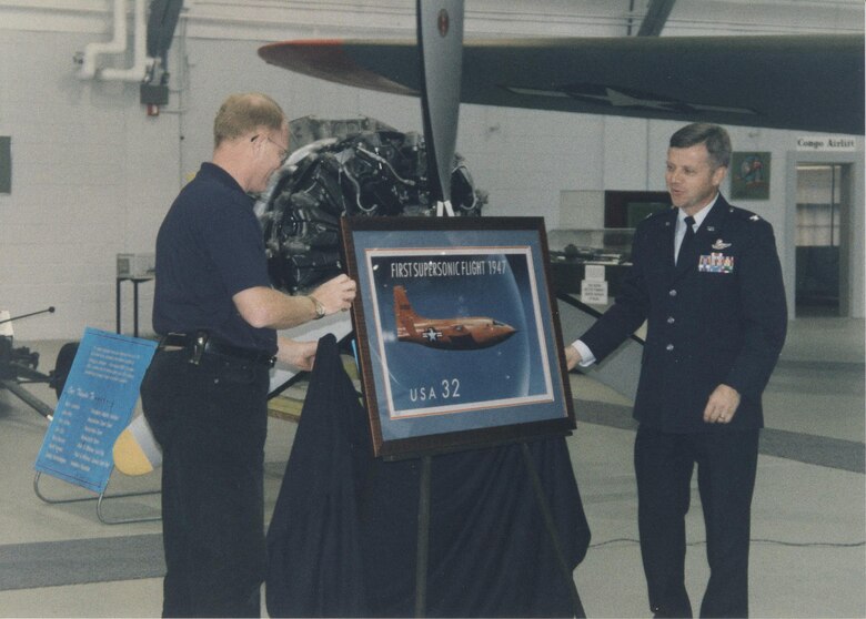 Mike Leister, Air Mobility Command Museum director, and Col. Felix Grieder, 436th Airlift Wing commander, unveil a commemorative U.S. Postal Service stamp September 1997, at the Air Mobility Command Museum on Dover Air Force Base, Del. This stamp was one of a series that honored the Air Force’s 50th anniversary. (Courtesy photo/Harry Heist)