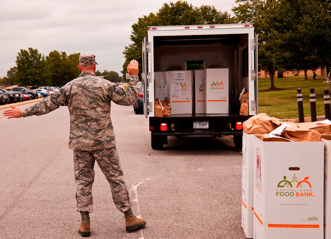 Senior Master Sgt. James Beckman, 89th Airlift Wing, marshals an 11th Logistics Readiness Squadron “bread truck,” driven by Staff Sgt. Harry Renninger, 11th LRS; as the two Airmen prepare to load the truck with 17 boxes of collected food at the 89th AW headquarters building, Joint Base Andrews, Md., Sept. 9, 2014. Beckman collected the boxes and he, Renninger, Tech. Sgt. Will Underhill, 89th AW, and Airman Jabari Wright, 11th LRS, loaded them for shipment to Waldorf, where they’ll feed needy families and support the U.S. Department of Agriculture’s Feds Feed Families campaign, which all Federal agencies, including Field components, can participate in. (U.S. Air Force photo by Master Sgt. Kevin Wallace/RELEASED)