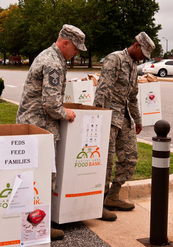 Senior Master Sgt. James Beckman, 89th Airlift Wing, and Airman Jabari Wright, 11th Logistics Readiness Squadron, move an approximate 150-pound box of food on an 11th LRS “bread truck” near the 89th AW headquarters building, Joint Base Andrews, Md., Sept. 9, 2014. The box was one of 17 and will be delivered to Waldorf to feed less-fortunate families in that area. (U.S. Air Force photo by Master Sgt. Kevin Wallace/RELEASED)
