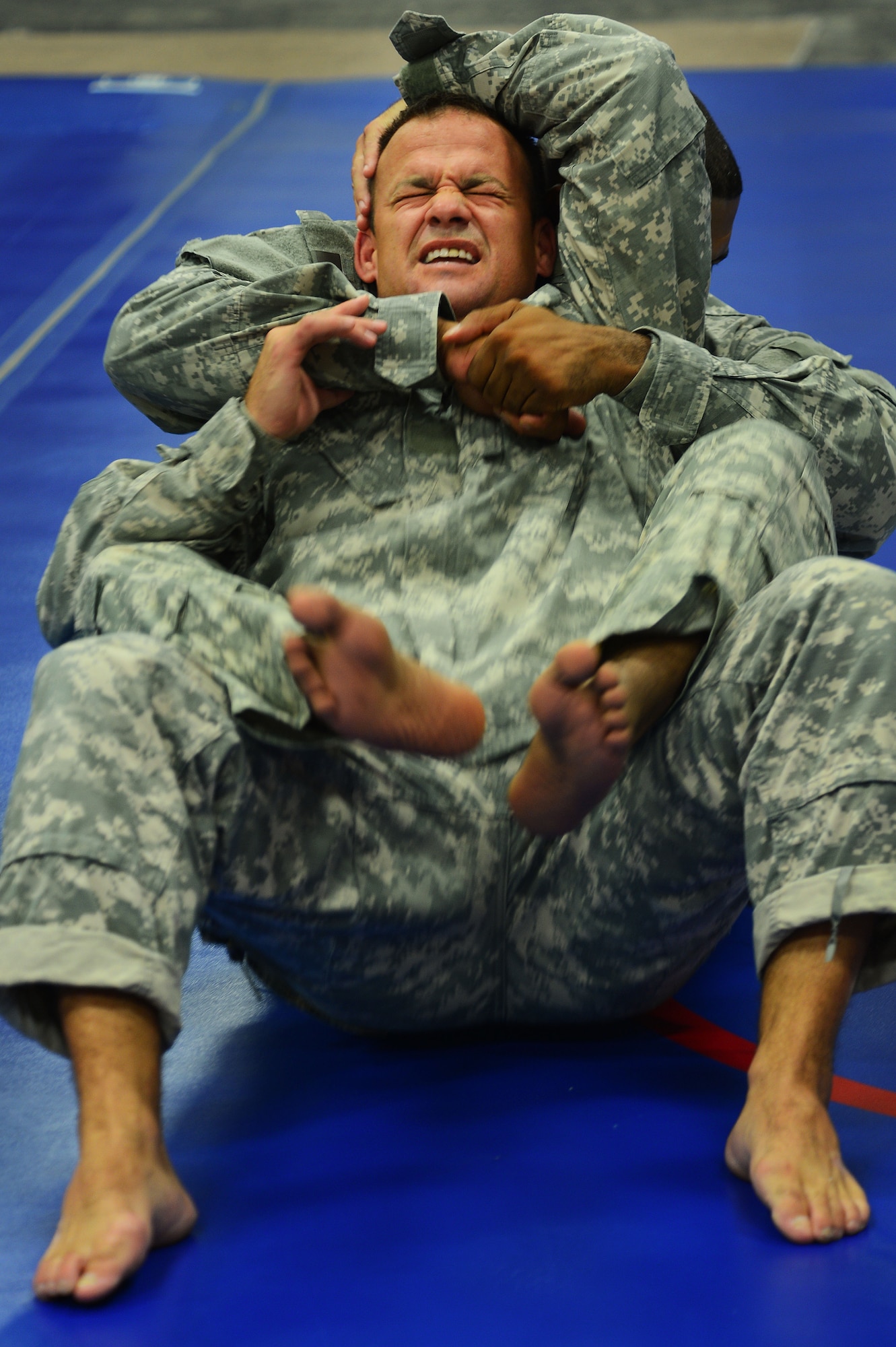 U.S. Army Maj. David Glad, U.S. Army Central medical logistics planner, attempts to break free from a rear mount choke during a combatives class at Shaw Air Force Base, S.C., Sept. 9, 2014. During the five day Modern Army Combatives Program, Airmen and soldiers learn several basic hand-to-hand combative techniques and practice to become proficient in each move. (U.S. Air Force photo by Airman 1st Class Jensen Stidham/Released)