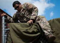 Staff Sgt. Juan Acevedo, 919th Special Operations Security Forces Squadron, demonstrates scaling a fence during a culmination exercise on the Eglin Air Force Base range, Aug. 27.  Duke Field’s reserve combat aviation advisors joined their active-duty counterparts for a five-day exercise of specialized spin-up training.  The Airmen move on to the Joint Readiness Training Center at Fort Polk, La., for further development. (U.S. Air Force photo/Tech. Sgt. Jasmin Taylor)