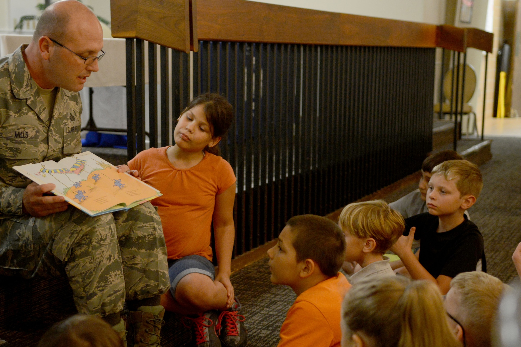 U.S. Air Force Chief Master Sgt. Charles Mills, 20th FW command chief, reads "Oh, the Places You'll Go" by Dr. Seuss  during a parents meet-and-greet at Shaw Air Force Base, S.C., Sept. 3, 2014. The event allowed military families to come together and learn more about what Shaw has to offer them as parents. (U.S. Air Force photo by Senior Airman Ashley Gardner/Released)