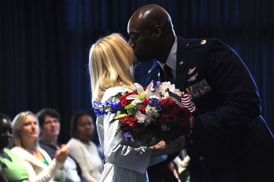 Maj. Johnnie Mason Jr. presents his wife, Ewa Mason, with flowers during the Air Force District of Washington bi-monthly retirement ceremony at Joint Base Anacostia-Bolling, Washington, D.C., June 27, 2014. The AFDW Ceremonies and Protocol staff coordinates the script, official photographer, presentation medal and provides 25 invitations to individuals participating in the Bi-Monthly retirement ceremony. (U.S. Air Force photo/Master Sgt. Tammie Moore)