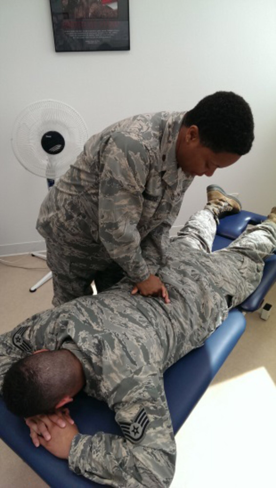 U.S. Air Force Major Latoya Crocker,  192nd Medical Group physical therapist, performs a medical procedure on an active duty Airman who came in for back pain.  The 192nd Medical Group sent 17 Airmen of varying specialties including doctors, nurses, medical technicians, physical therapists, logistic technicians and administrative support to the Spangdahlem Air Base Germany, Family Health Clinic July 12, 2014, where they treated approximately 275 patients and ensured active-duty military members and their families received quality health care this summer. (U.S. Air National Guard photo by Master Sgt. Samantha Mitchell/Released)