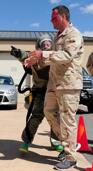 U.S Air Force Senior Airman Allydria Brown, 7th Aerospace Medicine Squadron dental assistant, points a simulated victim of a jet fuel explosion to the decontamination facility during in-place patient decontamination (IPPD) training Sept. 4, 2014, at Dyess Air Force Base, Texas. The goal of the training is to provide the IPPD team with the in-depth experience necessary to construct a decontamination facility with at least four personnel wearing protective gear within a specific time frame. (U.S. Air Force photo by Senior Airman Kia Atkins/Released)