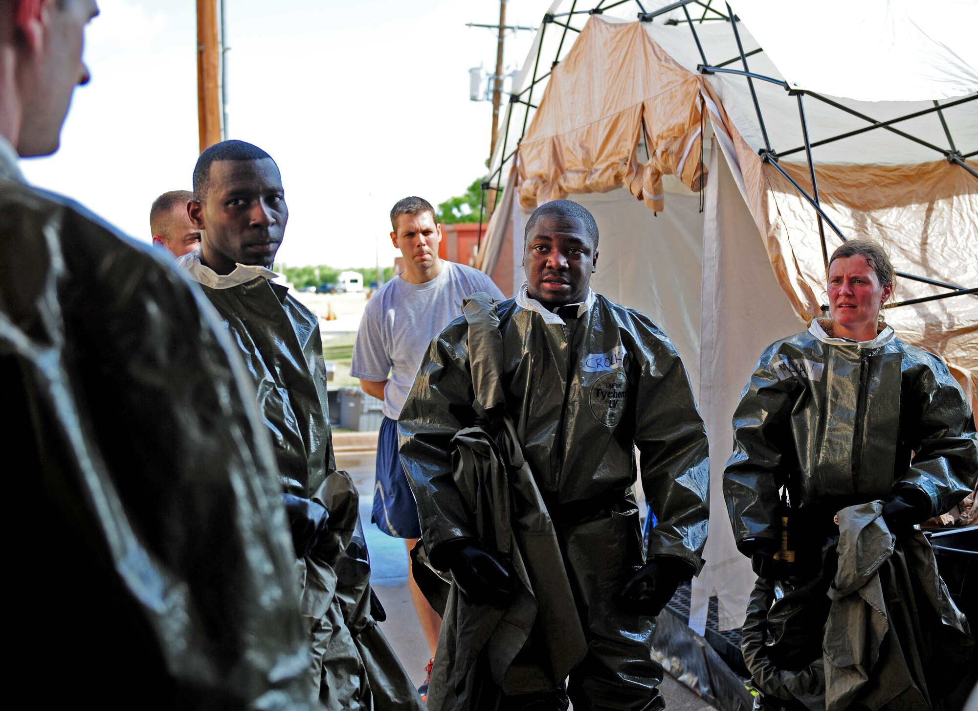 U.S. Air Force Airmen from the 7th Medical Group discuss issues they encountered while constructing a decontamination facility during in-place patient decontamination training Sept. 4, 2014, at Dyess Air Force Base, Texas. The team accomplished the task of setting up the decontamination tent so it was ready for patient care in 18 minutes, which was within the 20 minute time limit. (U.S. Air Force photo by Senior Airman Kia Atkins/Released)