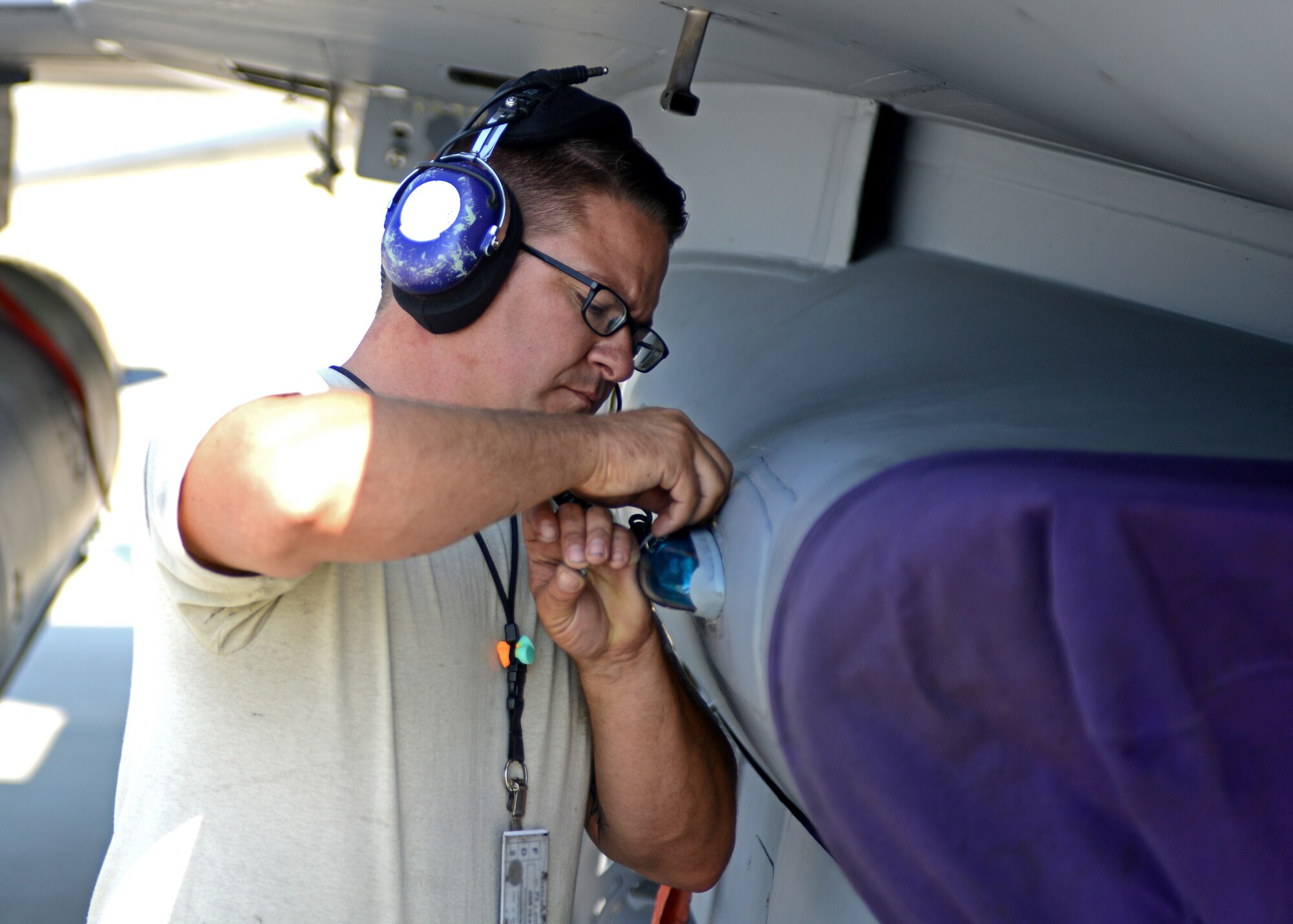 Senior Airman Joseph Archuleta, 31st Aircraft Maintenance Squadron assistant dedicated crew chief, changes a light bulb on an F-16 Fighting Falcon before the second go Sept. 8, 2014, at Lask Air Base, Poland. The seven F-16s and approximately 150 support personnel from the 31st Fighter Wing at Aviano Air Base, Italy, are supporting the NATO close air support exercise, Ample Strike. The exercise allows the 510th to work with a planned 11 nations to increase military relationships and NATO interoperability. (U.S. Air Force Photo/Tech. Sgt. Eric Donner)