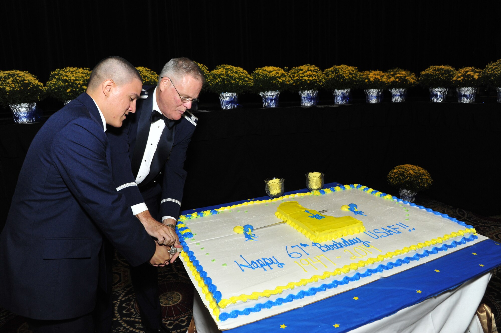Chaplain (Lt. Col.) James Parrish, 436th Airlift Wing chaplain, and Airman Armando Jimenez-Echevarria, 436th Maintenance Squadron munitions storage crew member, cut the Air Force birthday cake at the 67th Air Force Ball Sept. 6, 2014, at Dover Downs, in Dover, Del. It is Air Force Ball tradition to have the oldest and youngest Airmen cut the cake. (U.S. Air Force photo/Airman 1st Class William Johnson)