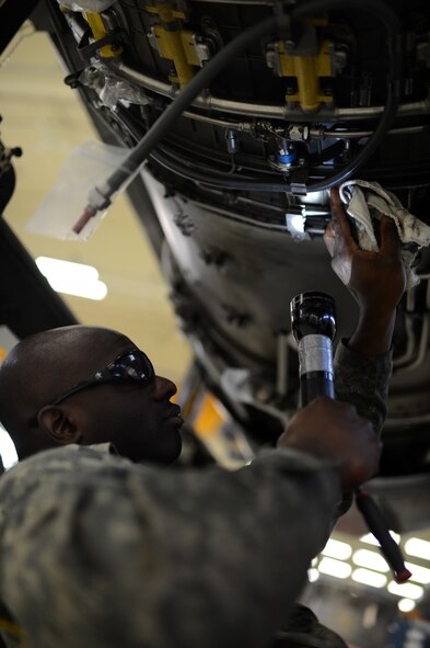 U.S. Air Force Staff Sgt. Condrienne Rice, a 52nd Component Maintenance Squadron propulsion flight technician and native of Montgomery, Ala., wipes down the bottom of an F-16 Fighting Falcon fighter aircraft engine Sept. 9, 2014. After maintenance, Airmen do a final check of loose nuts and parts while wiping the engine of excess oil and hydraulic fluid before sending it to be tested. (U.S. Air Force photo by Senior Airman Gustavo Castillo/Released) 